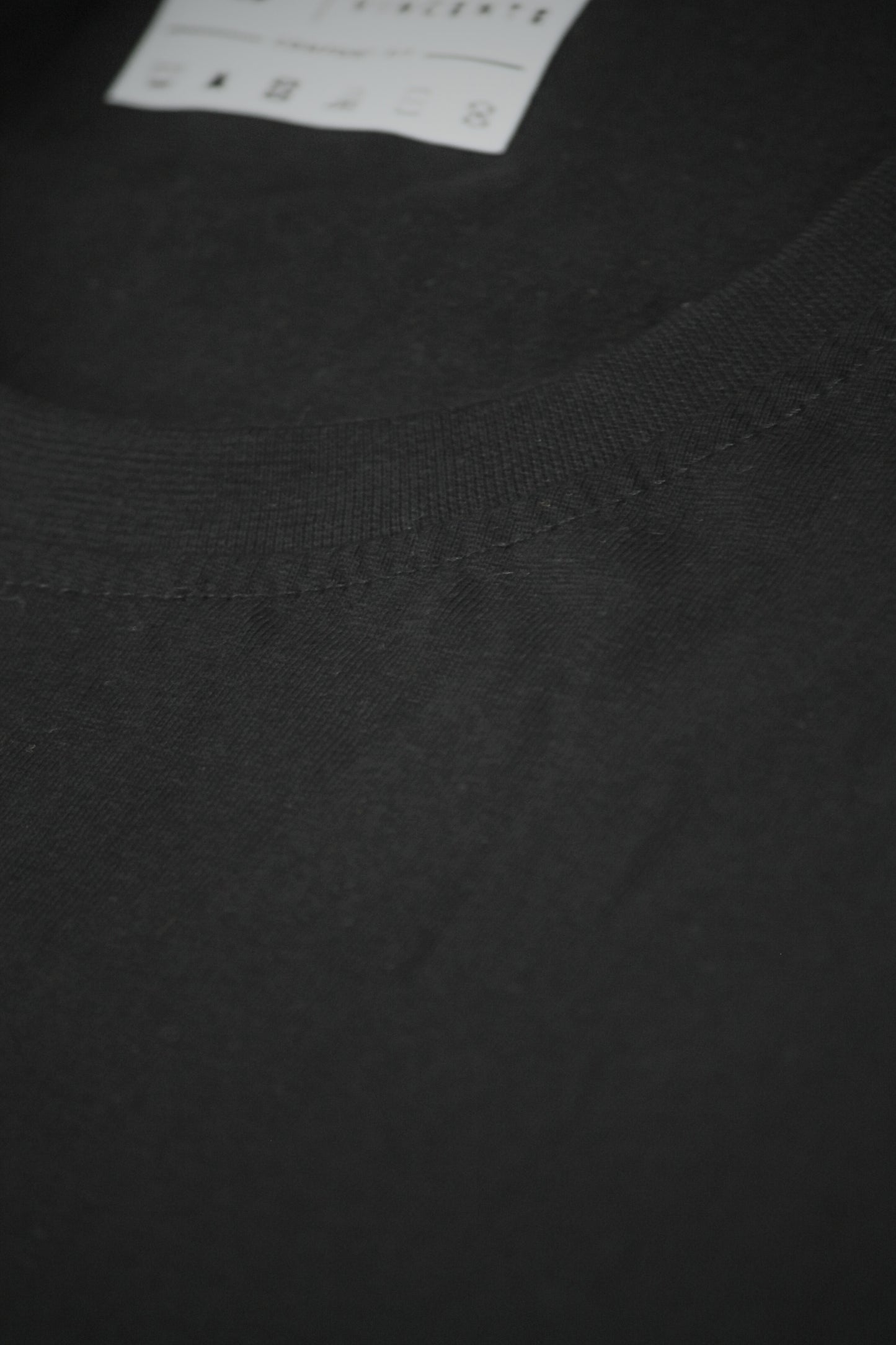 Close-up of a black tshirt neckline showing stitching